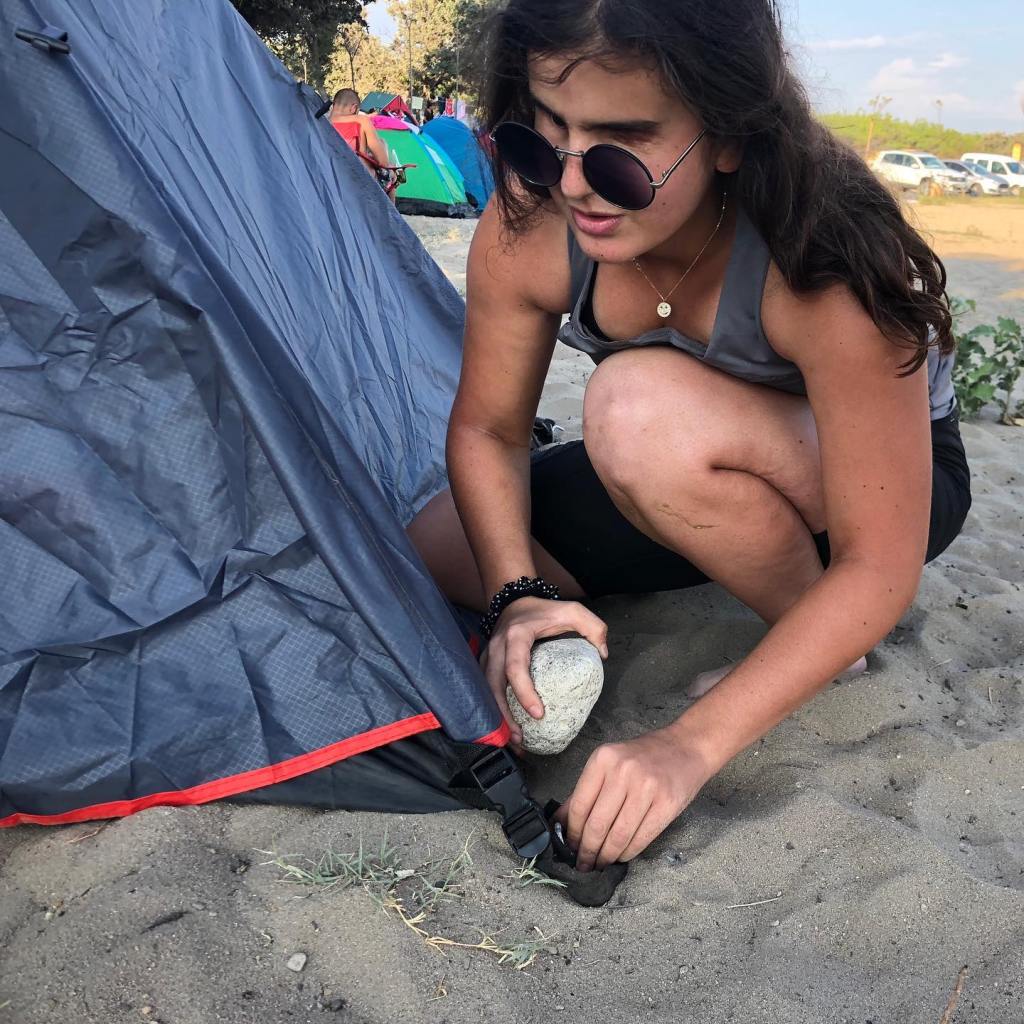 Melisa çadır kazığını çakarak çadırı kuruyor.